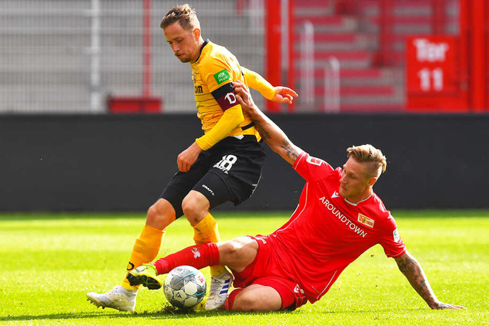 Dynamo-Kapitän Jannik Müller (l.) wird von Union-Angreifer Sebastian Polter attackiert.