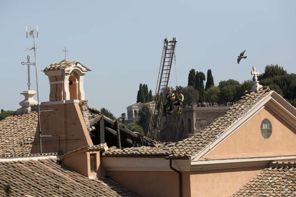 Feuerwehrleute untersuchen das eingestürzte Dach der Kirche San Giuseppe dei Falegnami.