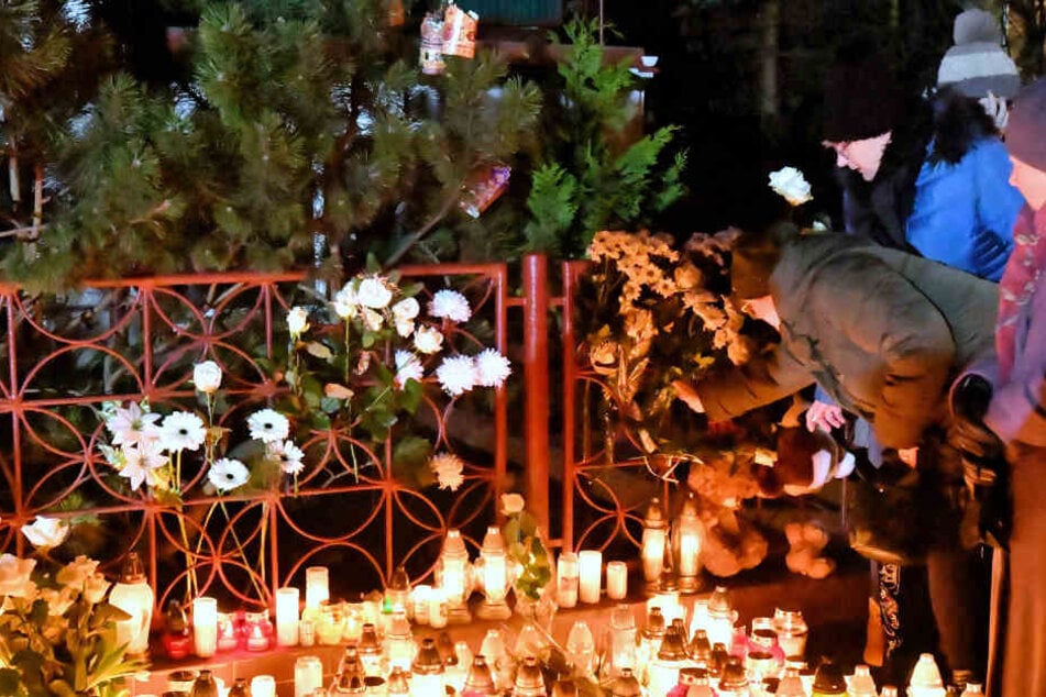 Blumen und Kerzen werden am Ort eines Brandes niedergelegt, bei dem fünf Mädchen gestorben sind.