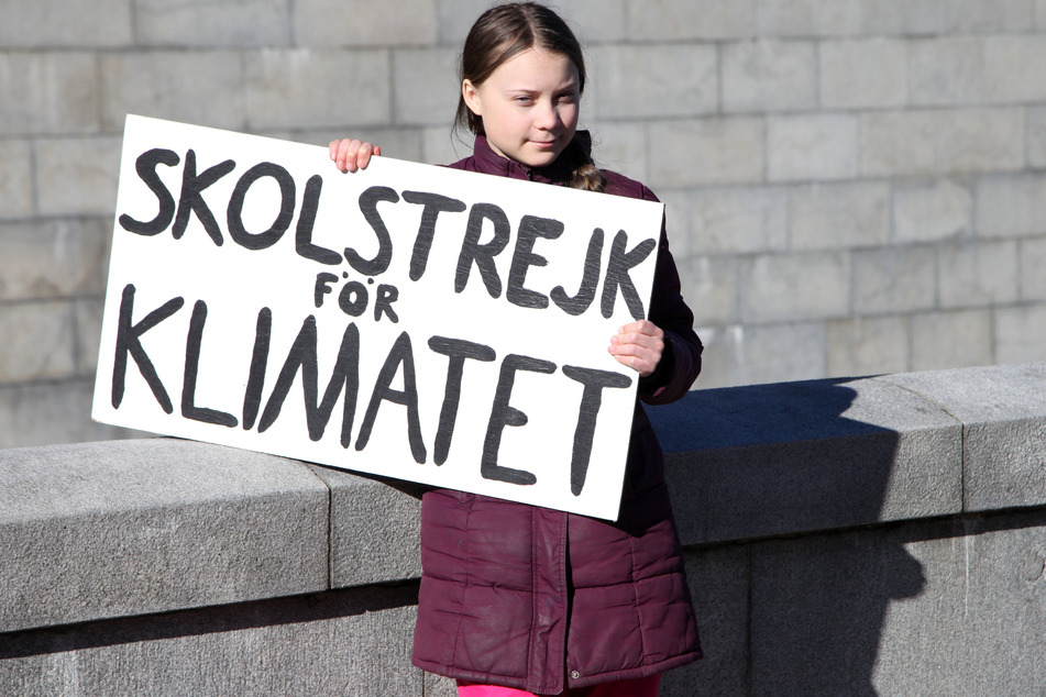 Greta Thunberg hält während ihres Schulstreiks vor dem Reichstag ihr Schild mit der Aufschrift "Skolstrejk för klimatet" (Schulstreik fürs Klima) in die Höhe.