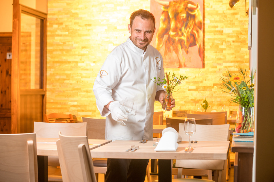 Daniel Fischer schmückt für seine ersten Gäste im "Daniels" die Tische mit frischen Blumen.
