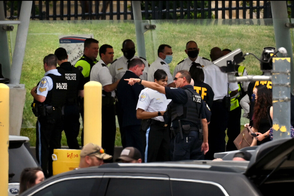 Law enforcement officers and first responders investigate the scene of a shooting incident with multiple injuries at a Metro bus platform outside the Pentagon in Arlington, Virginia.