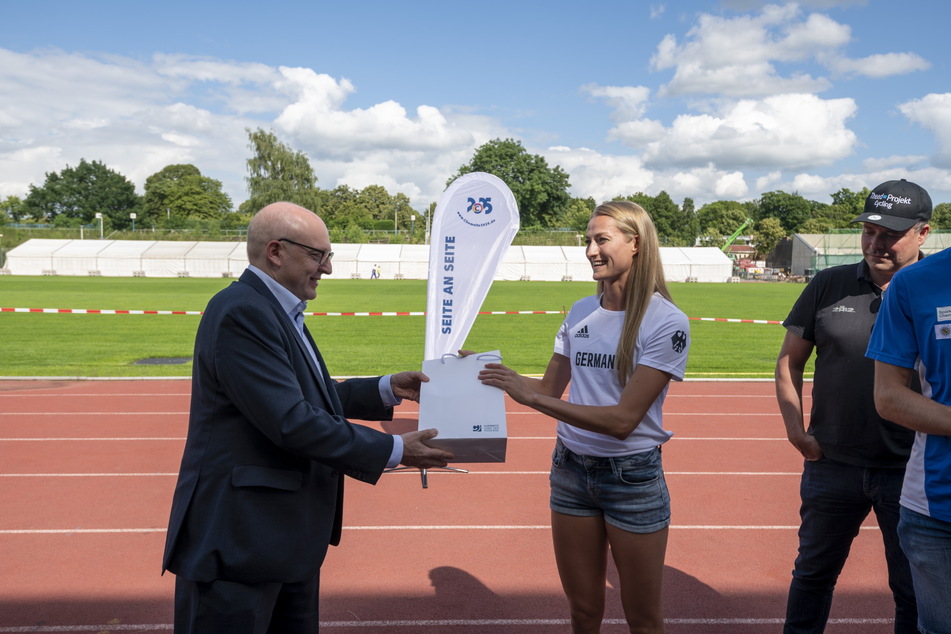 Sprinterin Corinna Schwab (22) nimmt das Geschenk vom Chemnitzer Stadtoberhaupt entgegen.