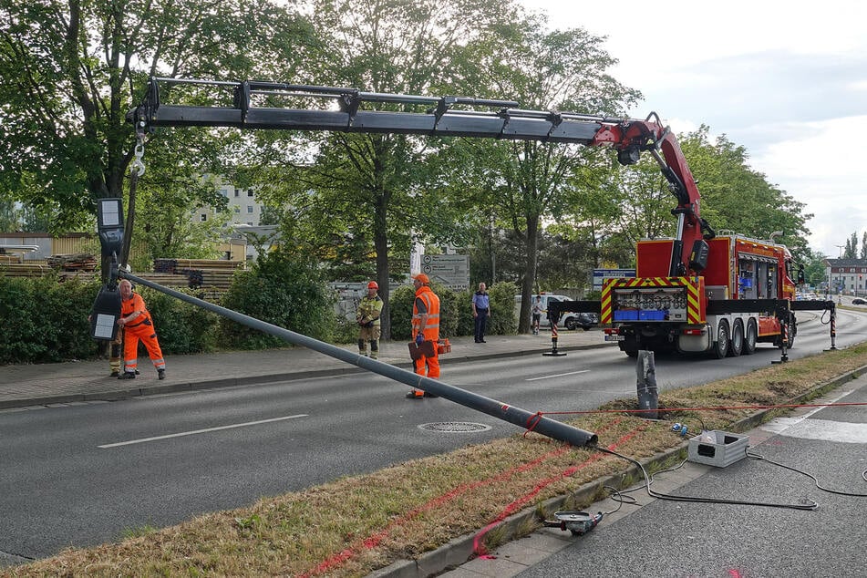 Mithilfe eines Krans des Rüstwagens der Feuer- und Rettungswache Albertstadt wurde der Lichtmast gesichert, bevor er mit einem Trennschleifer abgetrennt werden konnte.