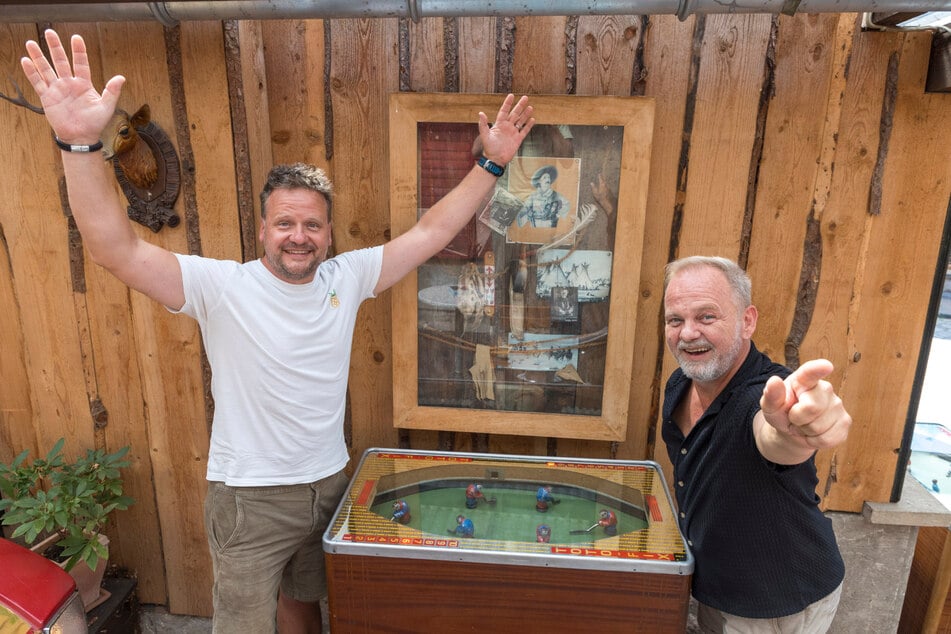 Michael Kramer (44, l.) und Steffen Grosche probieren einen Eishockey-Toto-Fix-Spielautomaten aus, der zur Pink Pixel Party aufgestellt wird.