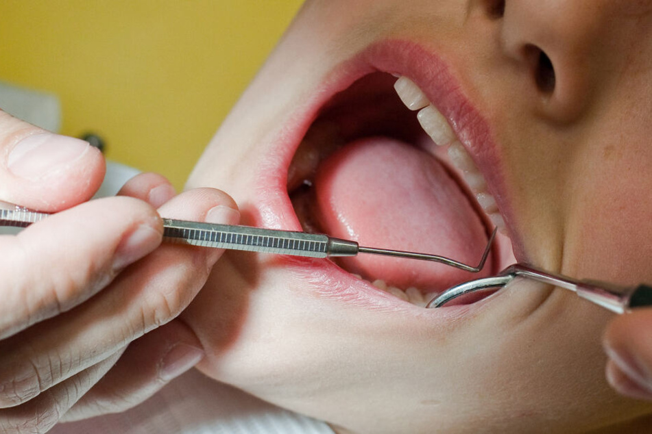 In einer Zahnarztpraxis werden die Zähne eines jungen Patienten untersucht (Symbolbild).