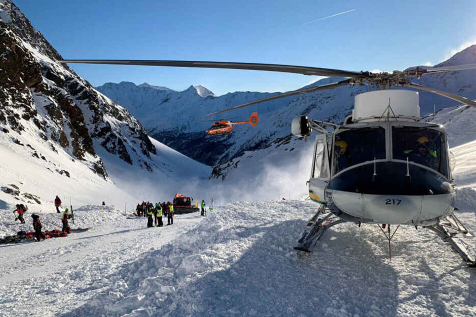 Ein Helikopter ist während der Suchaktion von Rettungskräften nach einer Lawine auf der Skipiste gelandet.