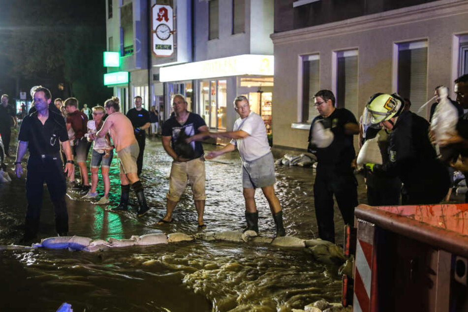 Helfer schleppten Sandsäcke gegen die Wassermassen.