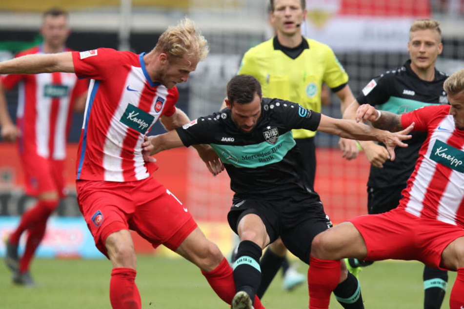 Die Heidenheimer Sebastian Griesbeck (l) und Niklas Dorsch (r) kämpfen mit dem Stuttgarter Gonzalo Castro um den Ball.