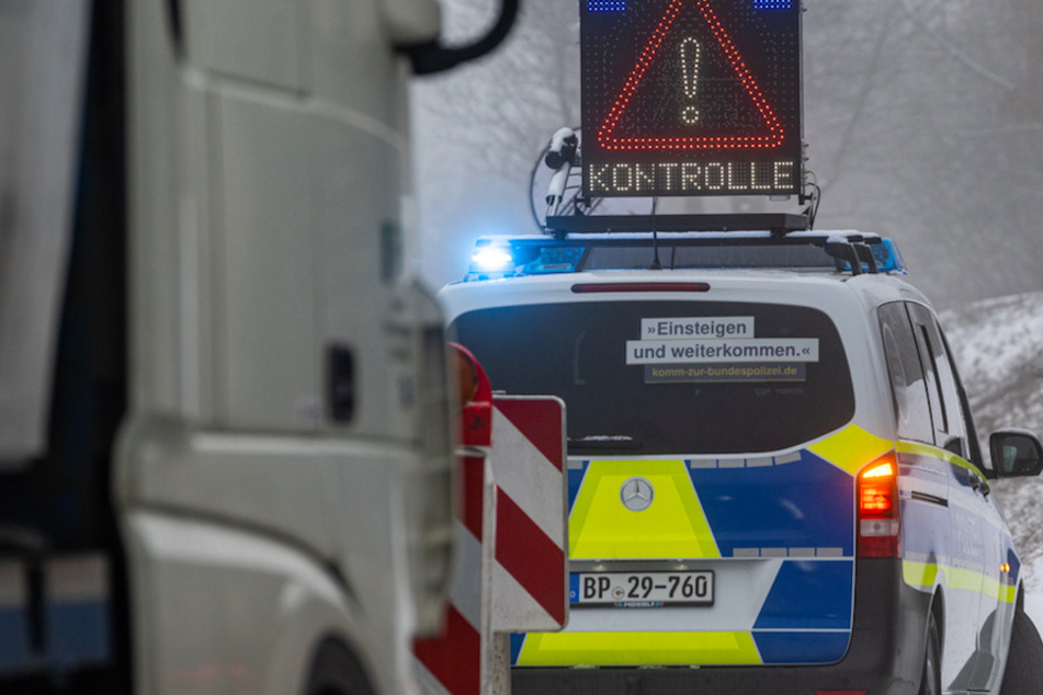 Ein Polizeiwagen kündigt am frühen Morgen eine Kontrolle kurz nach der deutsch-tschechischen Grenze an.