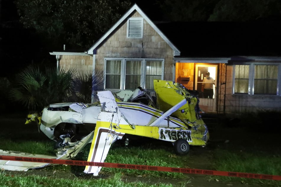 A shocked resident looks into his front garden after the plane crash.