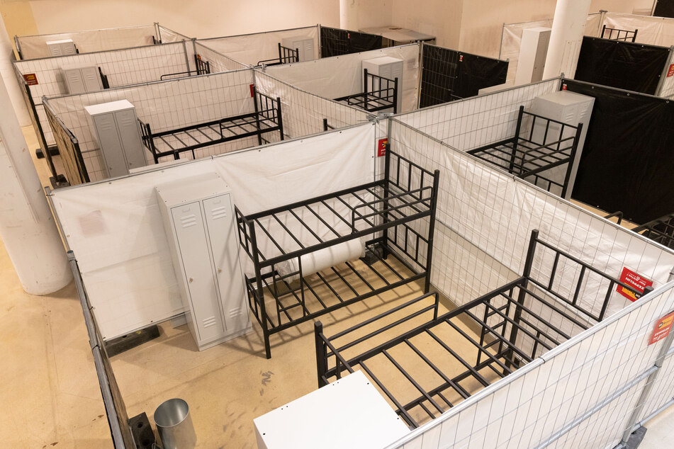 Stockbetten und Spinde stehen zwischen Sichtschutzzäunen in einer Freiburger Flüchtlingsunterkunft.