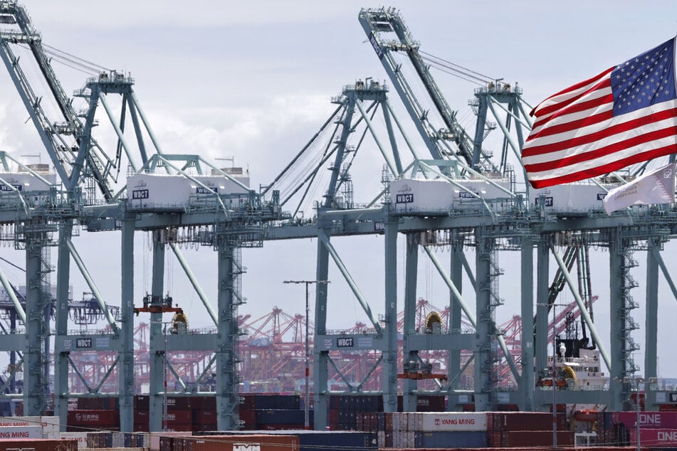An American flag flies near shipping cranes at the Port of Los Angeles on May 28, 2026.
