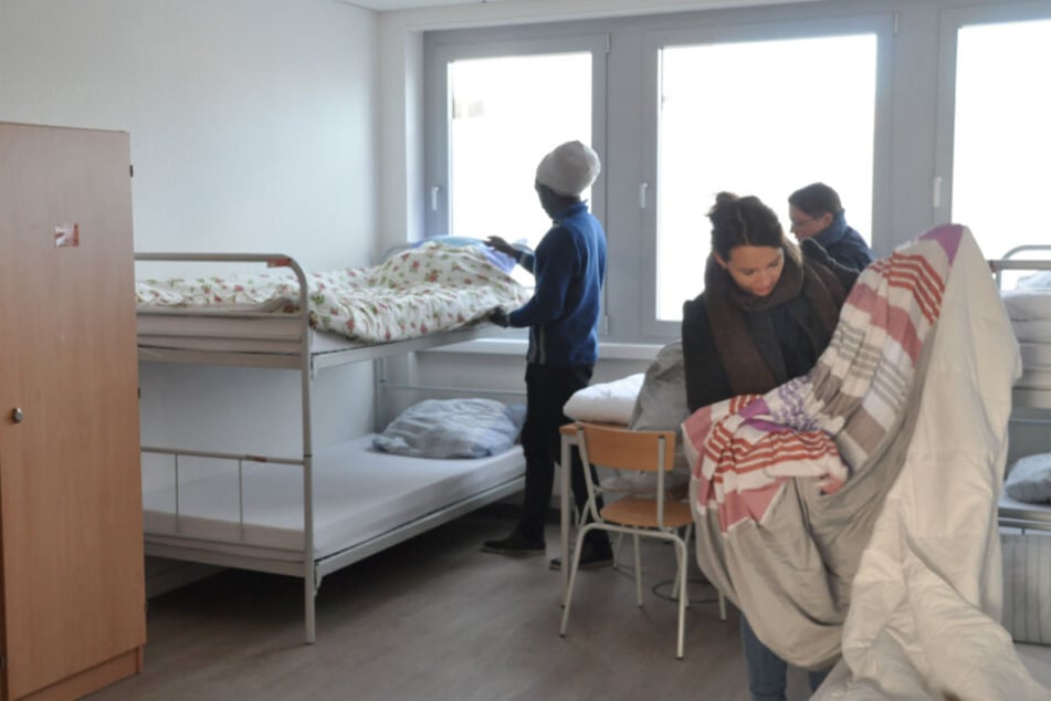 In einer Winternotunterkunft werden die Betten für die Obdachlosen bezogen.