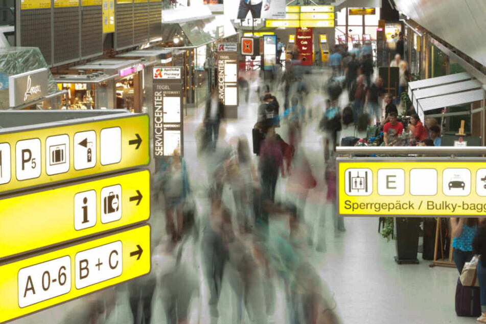 Passagiere laufen mit ihrem Gepäck durch den Flughafen Tegel.