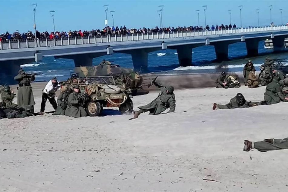 Während im Sand gekämpft wird, drängen sich Schaulustige auf der Seebrücke.