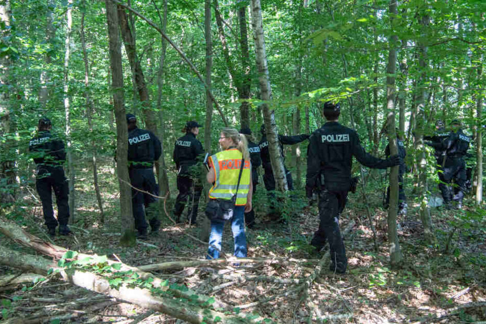 Polizisten suchen in einem Waldstück bei München nach den Leichen der Frau und ihrer Tochter.