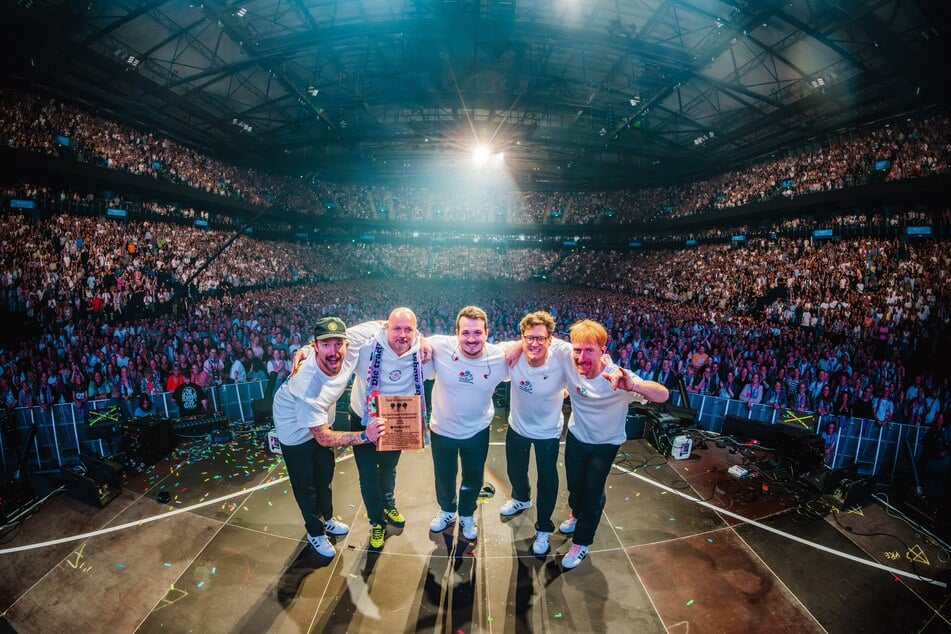 Mitglieder der Hamburger Goldkehlchen halten in der Barclays Arena ihren Fame-Forest-Award in die Kamera.