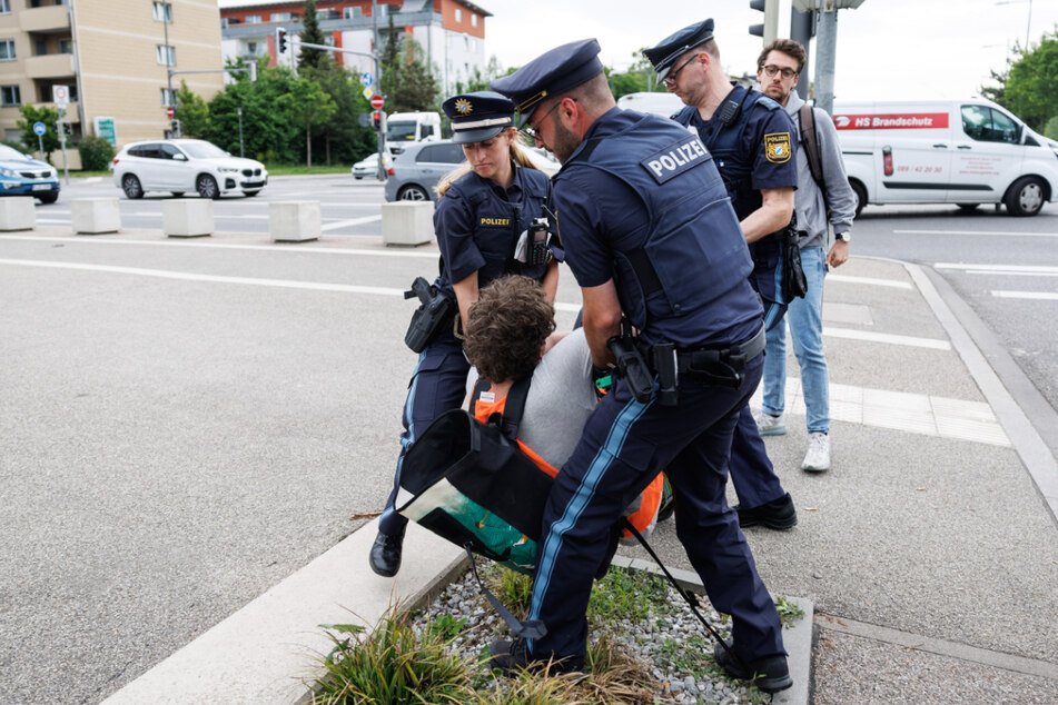 Immer wieder sorgt die "Letzte Generation" mit ihren umstrittenen Aktionen für Aufsehen. Hier wird ein Aktivist von der Münchner Polizei von der Straße getragen.