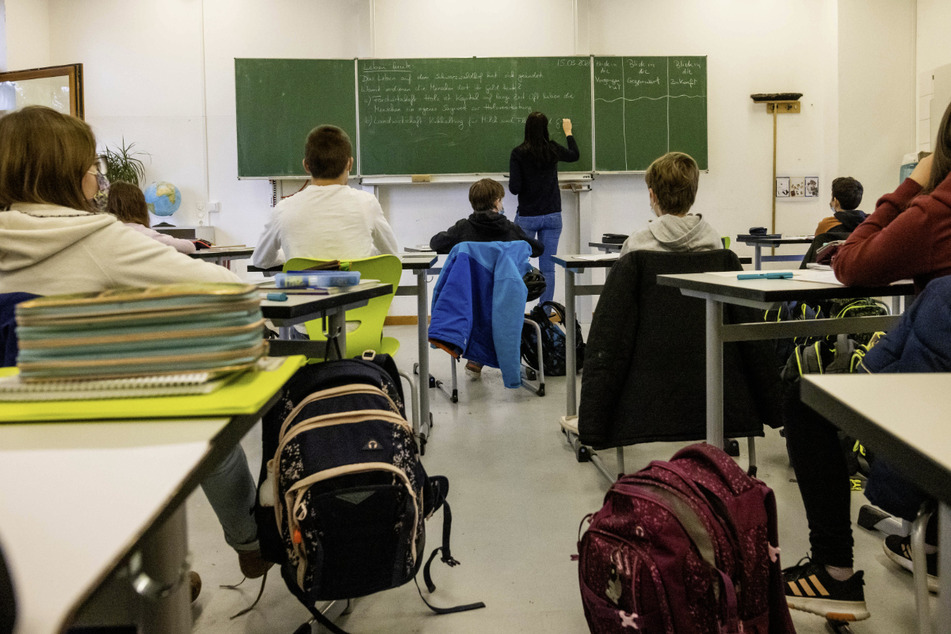 Schülerinnen und Schüler einer fünften Klasse sitzen während des Unterrichts in ihrem Klassenzimmer. (Archivbild)