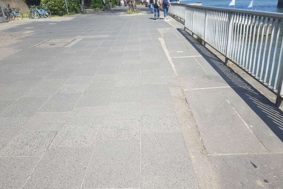 Schräge Verschnitte, graue Platten und teils lose Platten ebnen die "Flaniermeile" am Rhein.