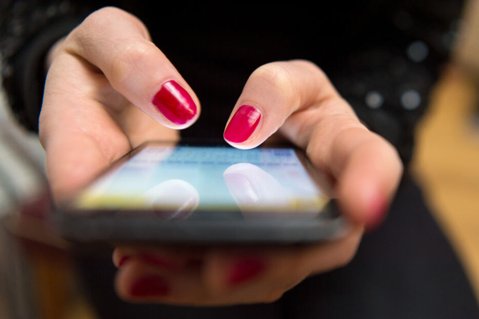 Eine Frau tippt auf einem Smartphone.