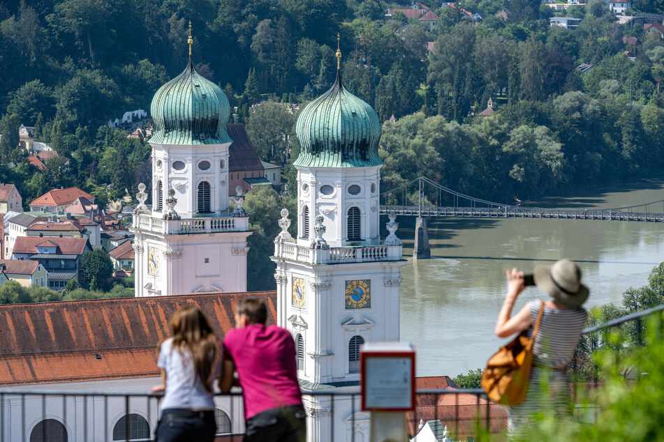 Passau: Touristen stehen bei sommerlichen Temperaturen vor dem Dom St. Stephan (Archivbild). Bayern hatte ein strikte Regelung, was Tourismus im Bundesland betrifft.