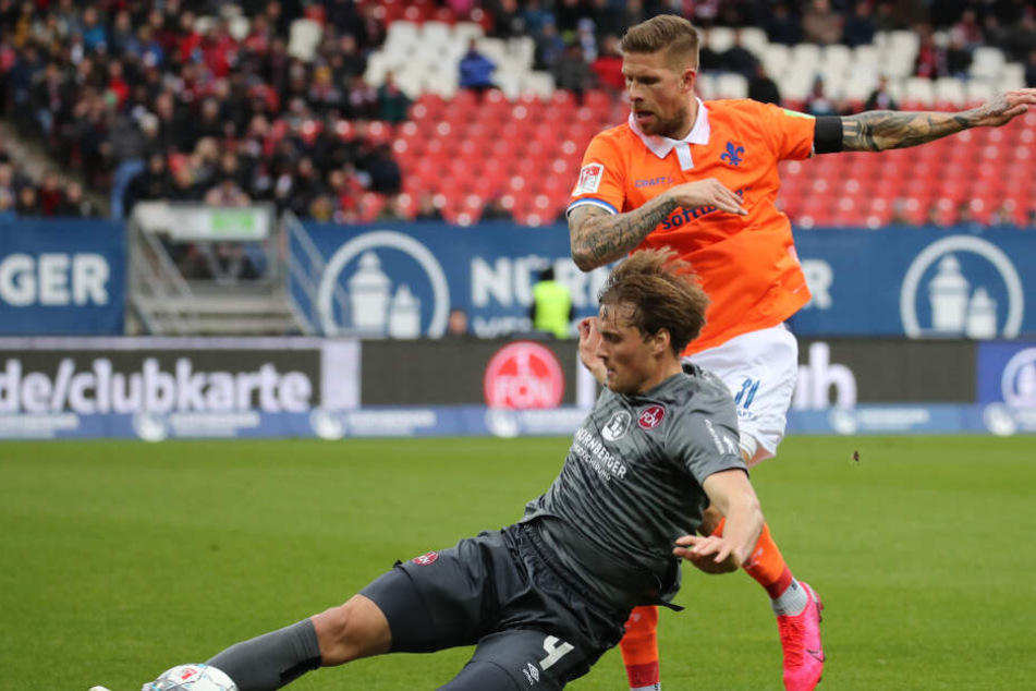 Der Nürnberger Asger Sörensen (l) kämpft mit dem Darmstädter Tobias Kempe um den Ball.