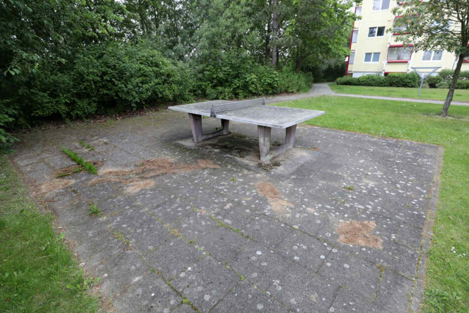 Auf einem Spielplatz unweit der Fundstelle eines toten Säuglings sind dunkle Stellen mit Sand abgedeckt, zuvor hat die Polizei die Spuren gesichert.