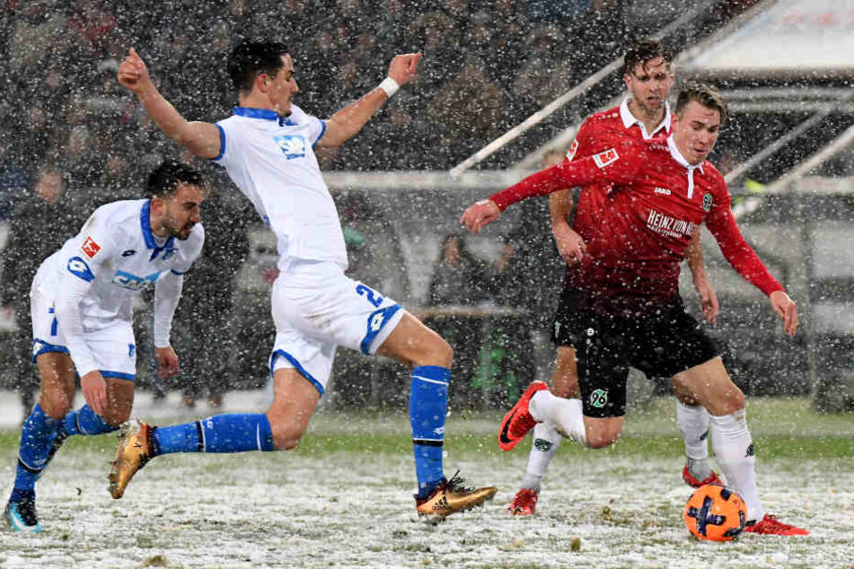 Hoffenheims Benjamin Hübner (Mitte) und Hannovers Felix Kraus (rechts) kämpfen um den Ball.