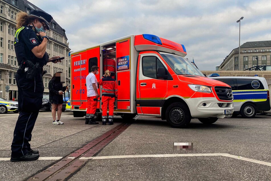 Das Opfer wird in einem Rettungswagen versorgt, auf dem Parkplatz liegt noch ein blutverschmiertes Tuch.