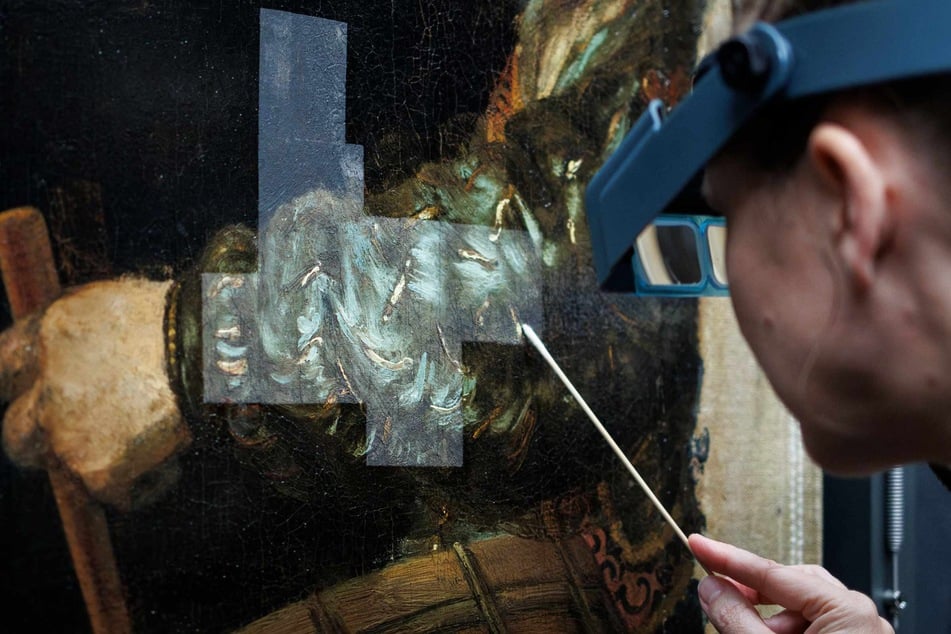 A technician works on the restoration of Rembrandt's masterpiece The Night Watch at the Rijksmuseum, in Amsterdam, on November 19, 2024.