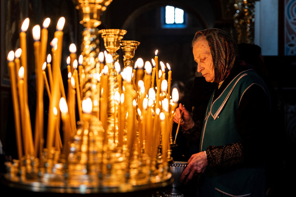 Eine Frau entzündet eine Kerze anlässlich des orthodoxen Weihnachtsfestes am 7. Januar im St. Michaelskloster in Kiew.