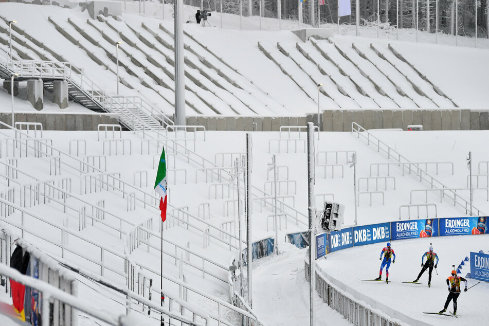 Biathleten trainieren beim Biathlon Weltcup im Stadion vor leeren Zuschauerrängen.