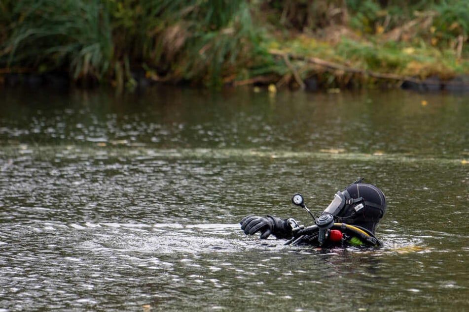 Ein Taucher der Feuerwehr sucht einen See nach Hinweisen ab. (Symbolbild)