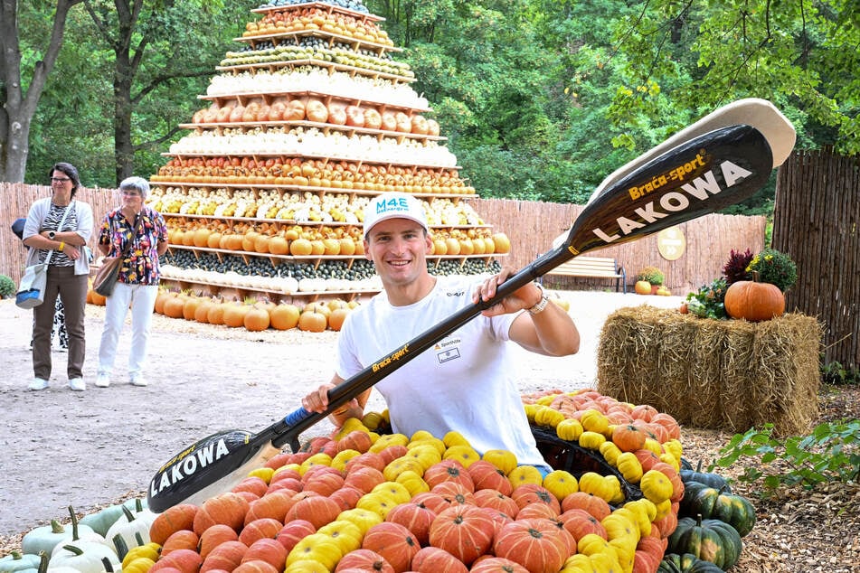 Tom Liebscher-Lucz (33) sitzt im Kürbis-Kanu vor der traditionellen, sechs Meter hohen Kürbis-Pyramide.