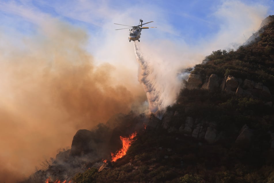 At least seven properties are known to have been destroyed in one of California's most exclusive communities as powerful winds pushed flames through steep canyons.