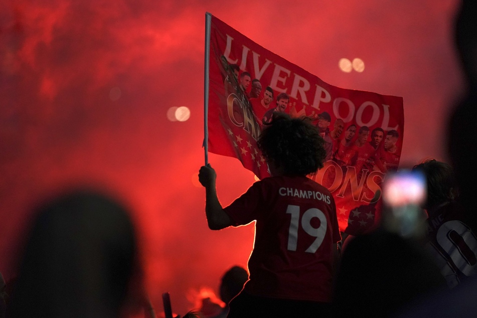 Fans des FC Liverpool feiern vor dem Stadion an der Anfield Road, nachdem ihre Mannschaft nach der 1:2-Niederlage von Manchester City gegen Chelsea als Meister der Premier League feststeht.
