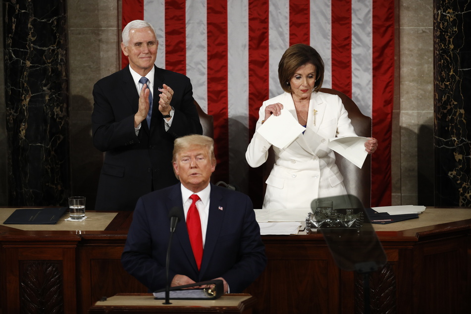 Nancy Pelosi (r), demokratische Vorsitzende des Repräsentantenhauses, zerreißt das Manuskript der Rede zur Nation von US-Präsident Donald Trump (vorne), nachdem dieser seine Ansprache gehalten hat. Vizepräsident Mike Pence (hinten, l) steht neben ihr.