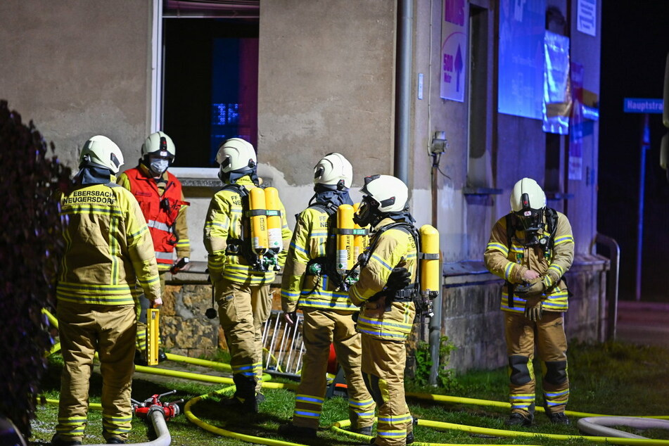 Die Feuerwehrleute am Haus an der Hauptstraße im Ortsteil Neugersdorf.