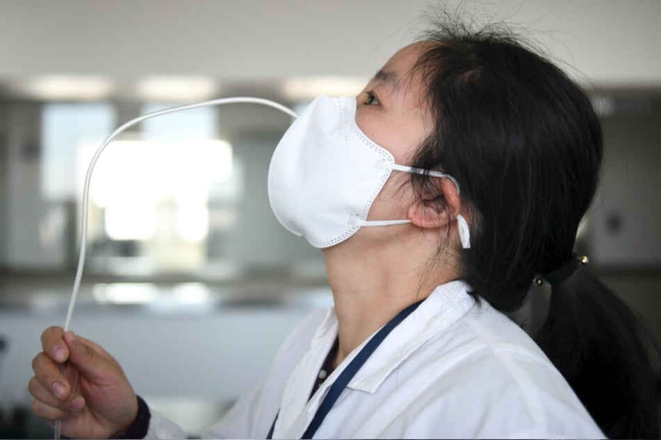 Kampf gegen das Coronavirus: Prüfer testen in einem Labor des Shaanxi-Instituts für die Qualitätsüberwachung von Medizinprodukten die Dichtheit einer Schutzmaske.
