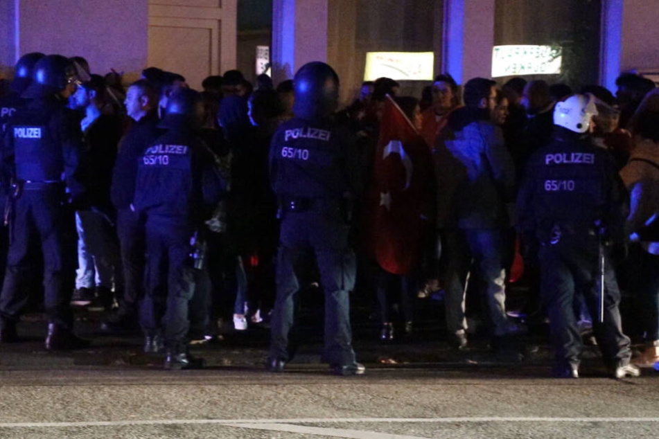 Polizisten stehen vor den Demonstranten.