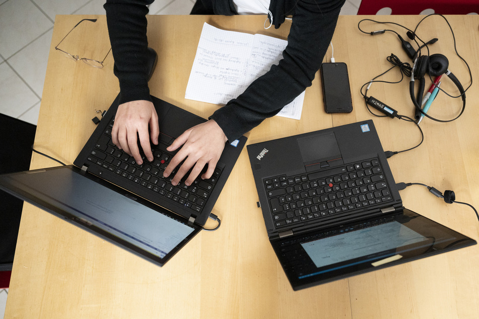 Eine Frau arbeitet an ihren Laptops.