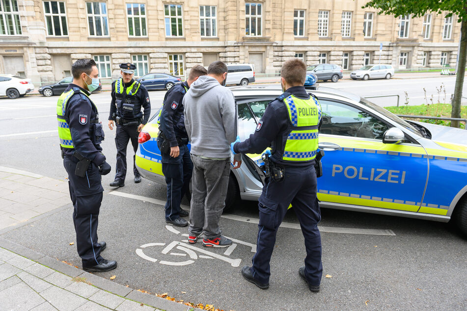Polizisten halten einen Mann fest.