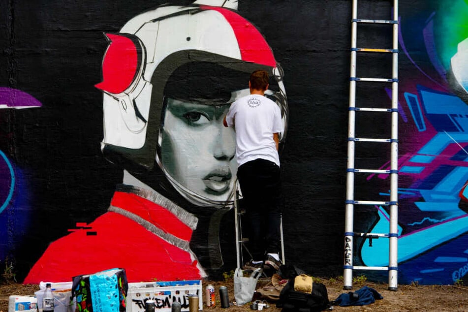 Ein Künstler arbeitet an einem Graffiti.