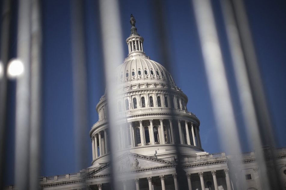 The United States Capitol is shown through newly installed barricades in Washington DC.