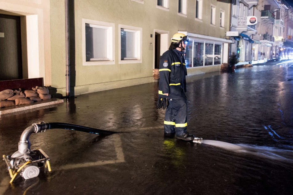 Ein Mitarbeiter des Technischen Hilfswerks pumpt in St. Blasien im Schwarzwald eine überflutete Straße leer.