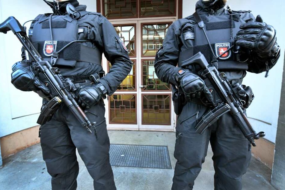Bewaffnete Polizeibeamte sichern einen Eingang zum Oberlandesgericht.