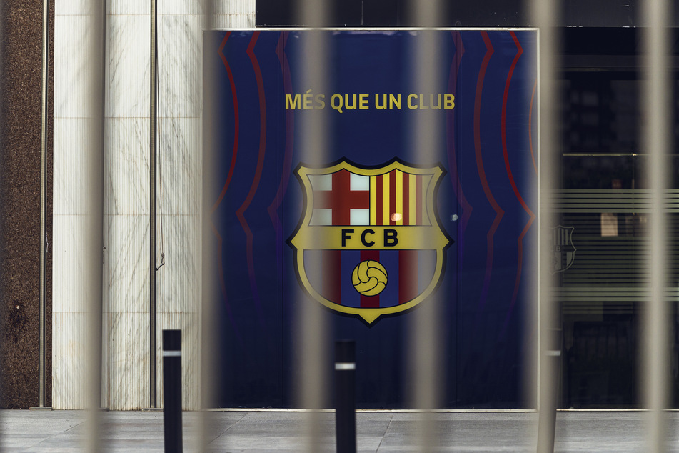 Blick auf das Wappen des FC Barcelona hinter den geschlossenen Toren des Camp Nou Stadions.