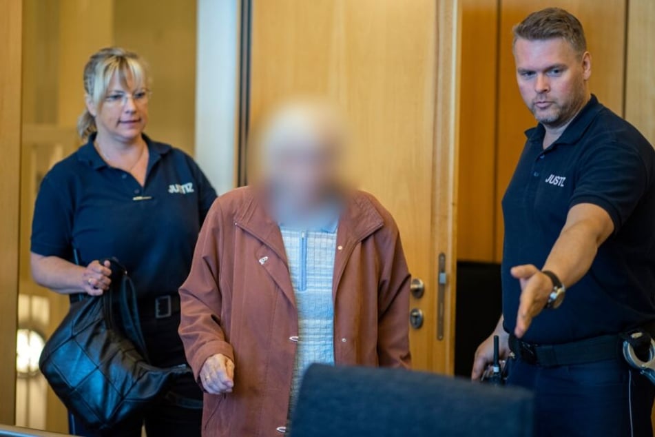 Die Angeklagte wird beim Prozessbeginn im Landgericht Münster von zwei Justizbeamten in den Saal geführt.